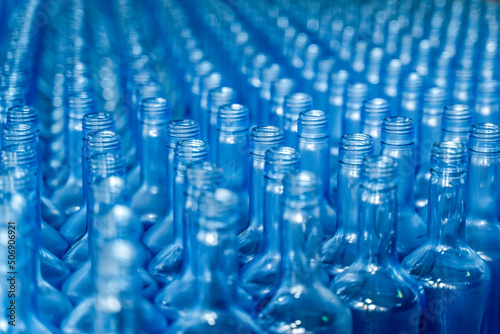 Alcohol beverage factory. Bottles on conveyor belt of bottle cleaning filling and capping machine