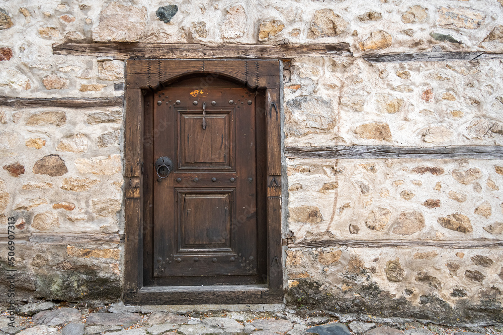 Ancient wooden door in stone castle wall