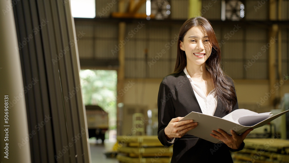Portrait of Asian young woman factory quality inspector hold document folder and looking at camera
