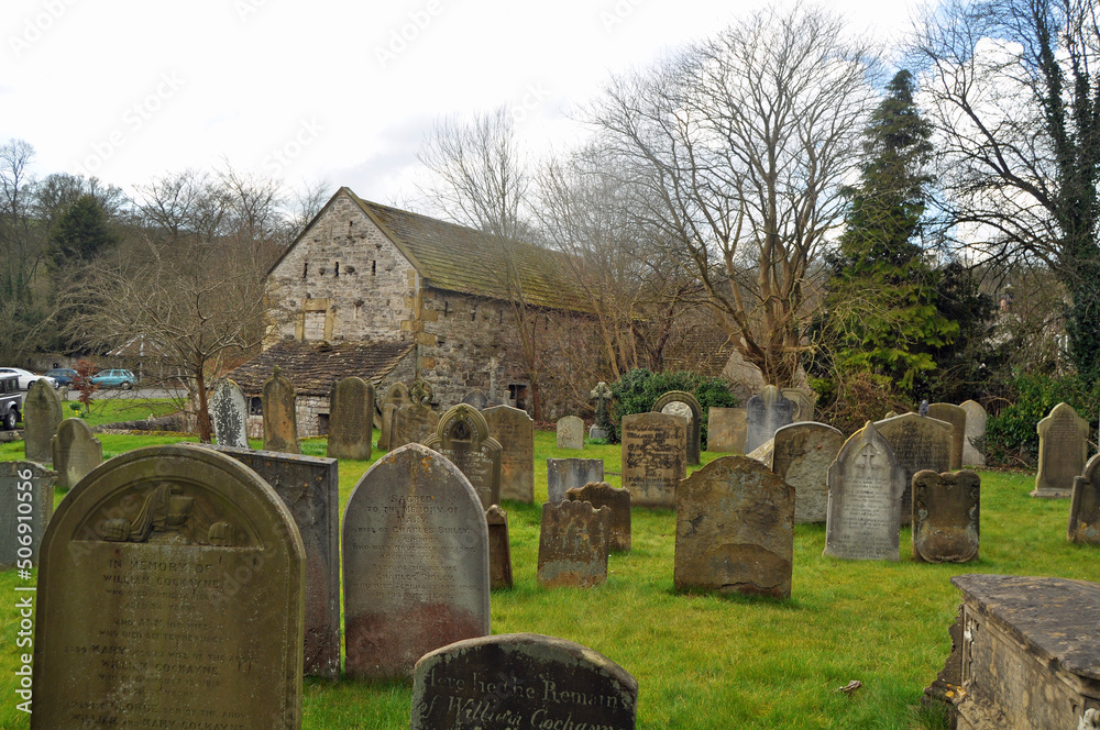 The pretty, typical Holy Trinity Church and churchyard with graves in picturesque Ashford In The Water Derbyshire U.K.