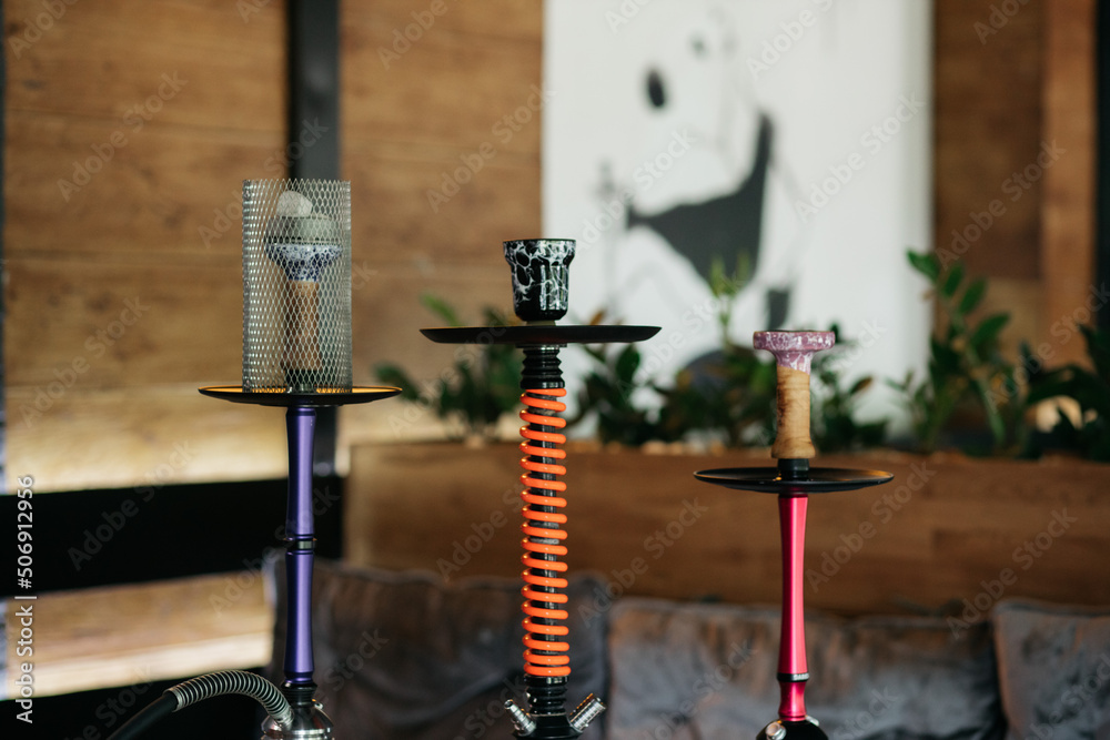 Hookah smoking at a party concept. Hookah stands on a wooden table in a restaurant. Smoking concept. Hookah on the table. Smoking tobacco. Hookah smoking at a party concept. Hookah stands on a wooden table in a restaurant. Smoking concept. Hookah on the table. Smoking tobacco.