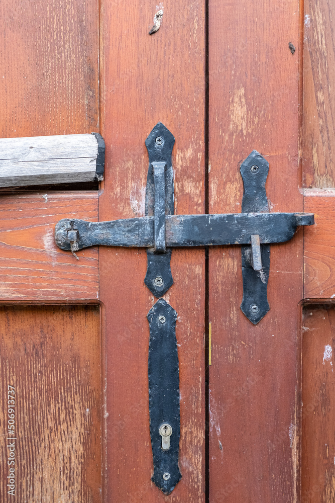 Antique iron locking system on a wooden door Antique iron locking system on a wooden door
