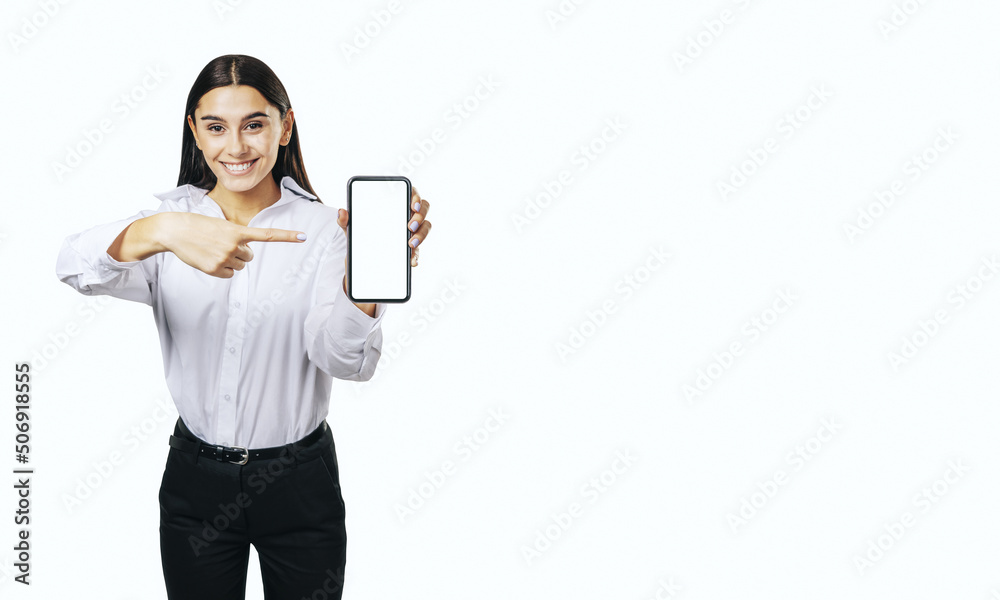 Mobile application concept with smiling businesswoman in white shirt showing modern smartphone with blank white screen isolated on light background with place for your logo or text, mock up Mobile application concept with smiling businesswoman in white shirt showing modern smartphone with blank white screen isolated on light background with place for your logo or text, mock up