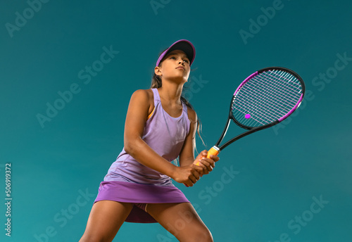 Tennis player. Beautiful girl teenager and athlete with racket in pink sporswear and hat on tennis court. Fashion and sport concept. © Mike Orlov