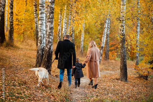 Ukrainian family walks in nature with their son and dog