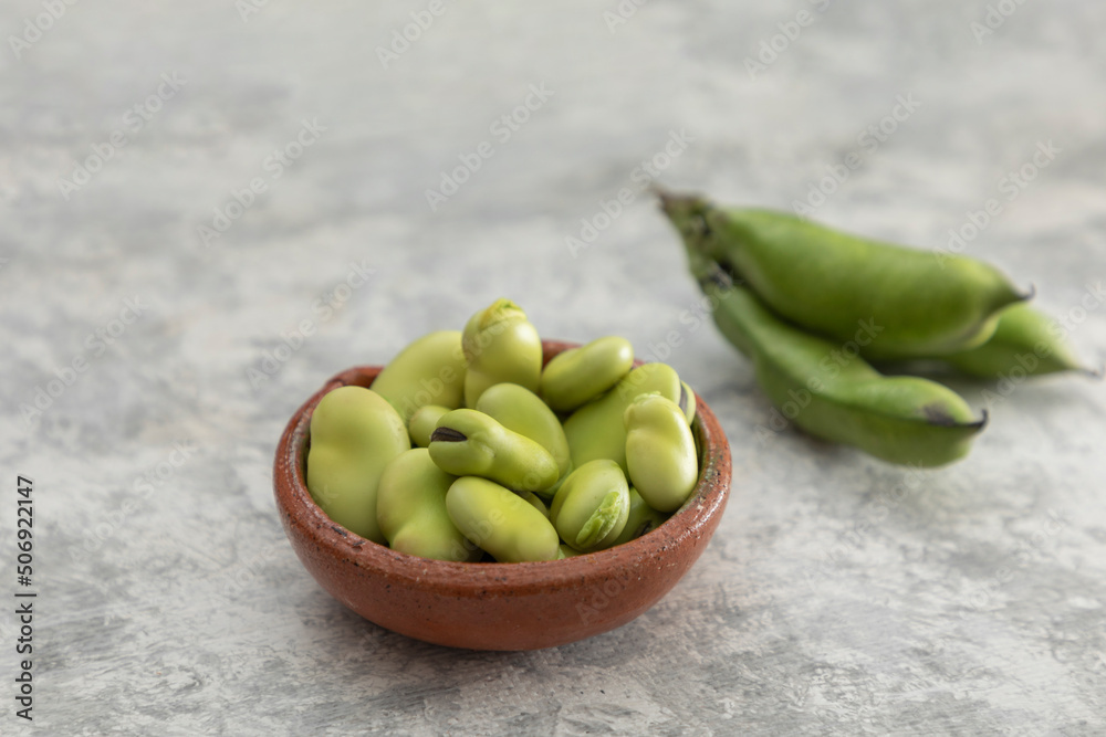 composition of peeled and shelled broad beans on a gray texture and copy space composition of peeled and shelled broad beans on a gray texture and copy space