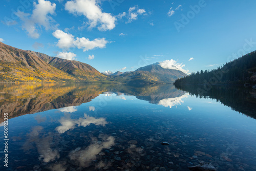 Perfect reflection; mountains in autumn colors reflect in a lake, Yukon territory, Alaska
