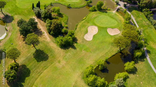 Aerial view of a golf course in the morning. There are no people on the putting green.