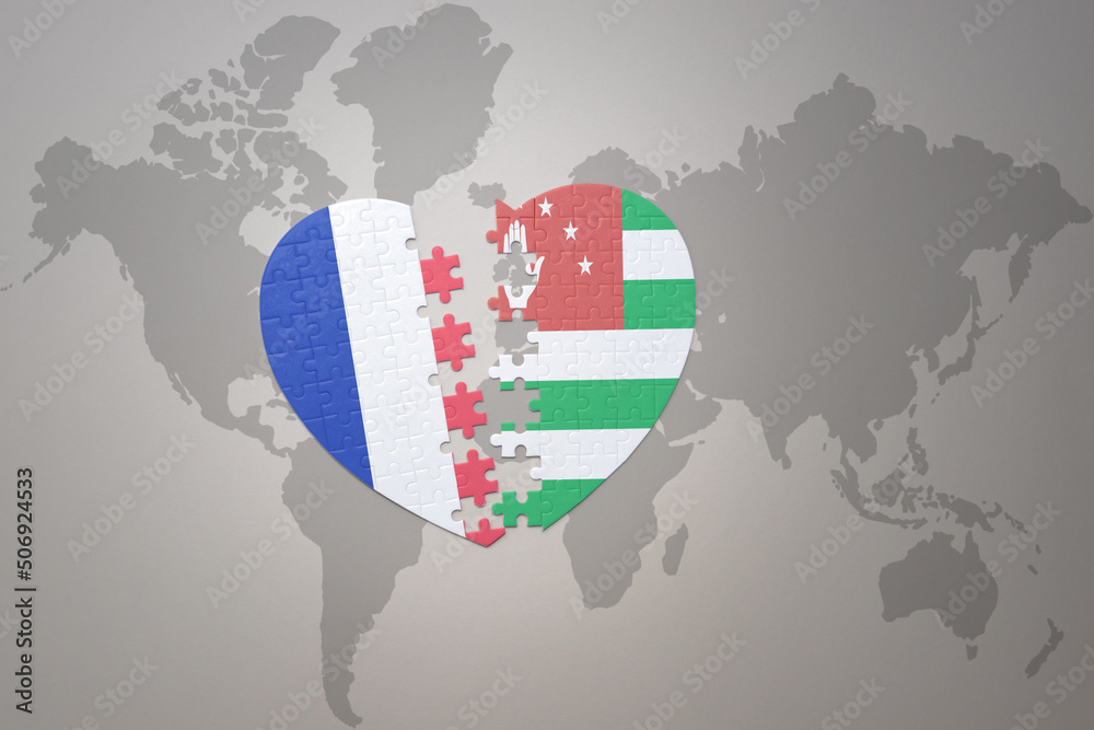 Fototapeta premium puzzle heart with the national flag of france and abkhazia on a world map background. Concept.
