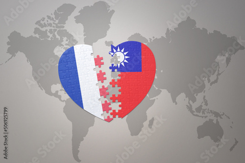puzzle heart with the national flag of france and taiwan on a world map background. Concept.