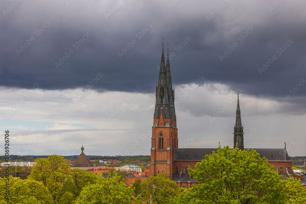 Beautiful landscape view of top towers of Uppsala Cathedral Church on thunderclouds sky. Sweden. 