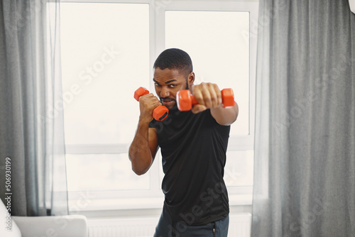 Handsome Afro American sportsman working out at home photo