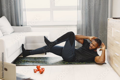 Handsome Afro American sportsman working out at home photo