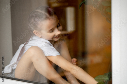 portrait of a girl sitting on the windowsill