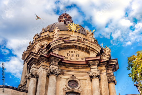 Dominican Church central facade at summer sunset on clear sky. Architecture of old Lviv city in Ukraine. Bottom view of the inscription - Soli Deo photo