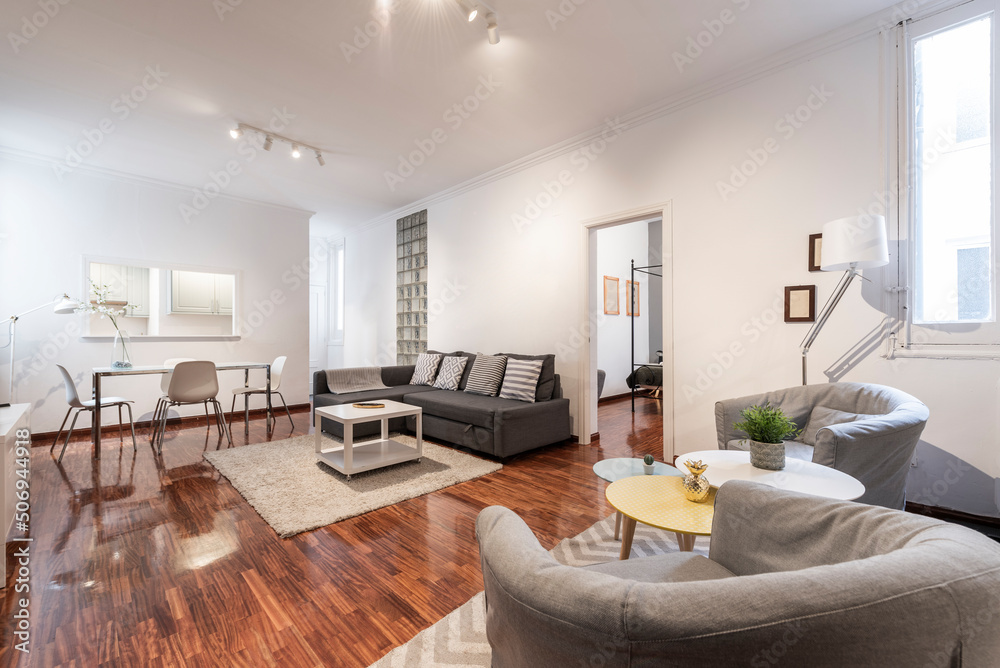 spacious living room with wingback sofas, auxiliary coffee tables, sofa bed with chaise longue, chromed metal dining table and white glass top