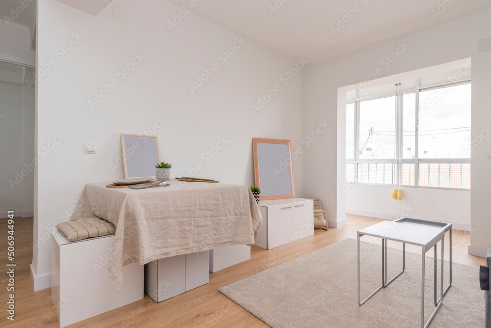 Fototapeta premium Living room with dining table with linen tablecloth and glazed terrace