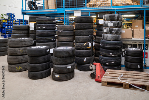 in a depot of a car repair shop there are many summer tires ready for a wheel change photo