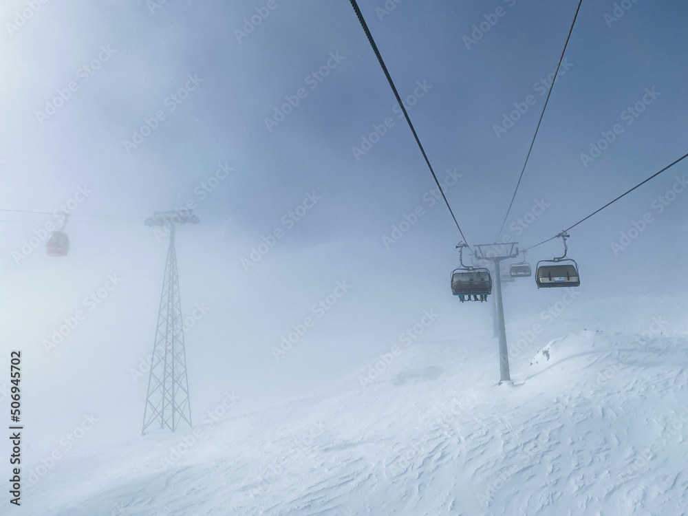 ski lift chairs in heavy fog on snowy mountains, bad weather, copy space ski lift chairs in heavy fog on snowy mountains, bad weather, copy space