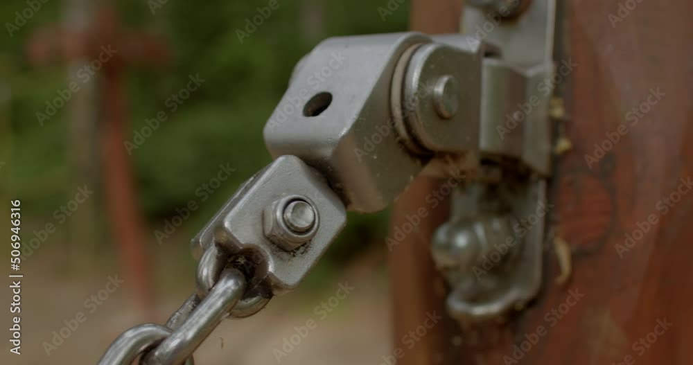 The movement of the metal connection of the carabiner on the chain. The bolt and nut hold the joint. Chain tension, an engineering invention. Soft focus. The movement of the metal connection of the carabiner on the chain. The bolt and nut hold the joint. Chain tension, an engineering invention. Soft focus.