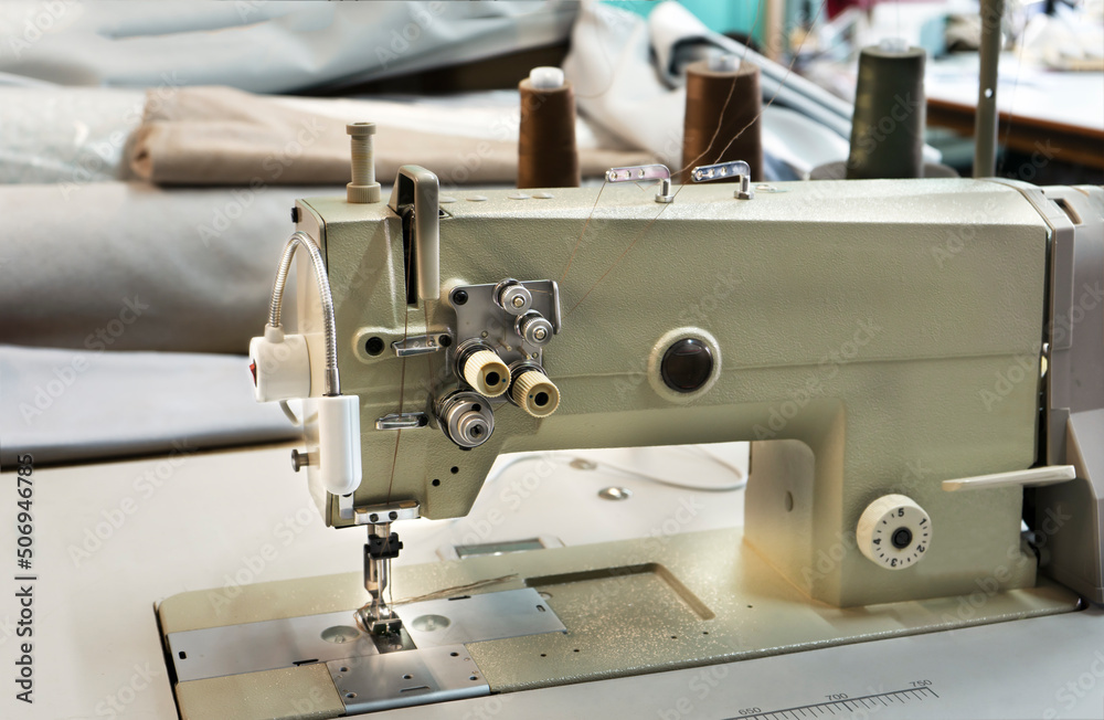 Industrial sewing machine. Textile factory sewing workshop.