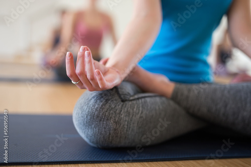 Closeup of yoga meditation in lotus pose at modern studio