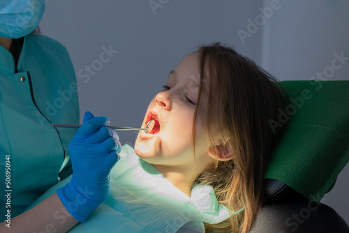 Process of Hygiene of Child Teeth. Little Girl in a chair of Dentist Hygienist during regular visit.