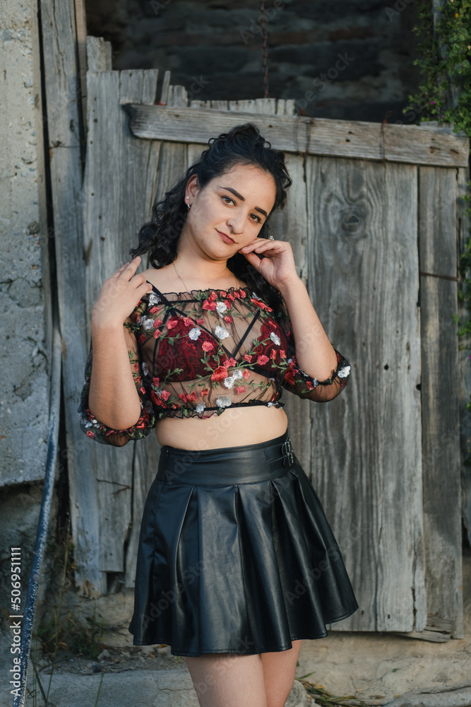 Fototapeta premium Sexy Latina poses in a sheer top and black skirt
