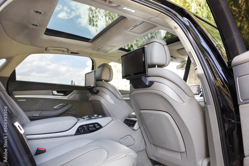 Modern luxury car interior with empty touch monitors in headrests with copy space.