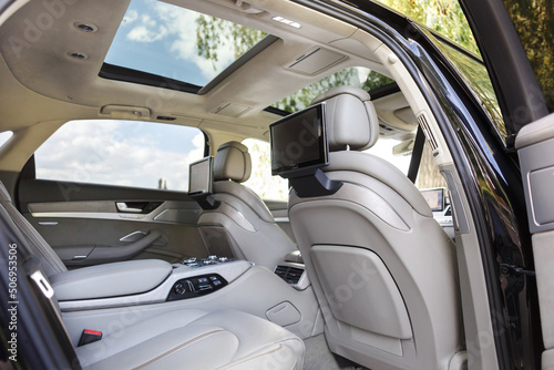 Modern luxury car interior with empty touch monitors in headrests with copy space. © kucheruk