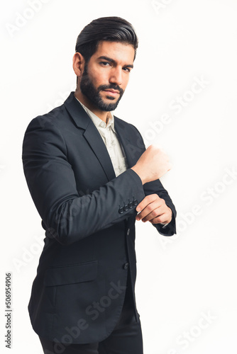 young man wearing a suit fastering a button while looking at the camera, isolated white background. High quality photo photo