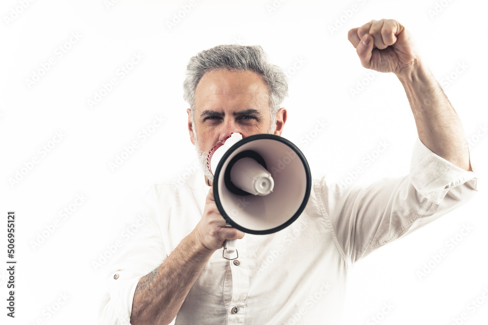 Closeup studio portrait with white background of a caucasian middle-aged silver-haired man using loudspeaker and showing his fist. Copy space. High quality photo Closeup studio portrait with white background of a caucasian middle-aged silver-haired man using loudspeaker and showing his fist. Copy space. High quality photo