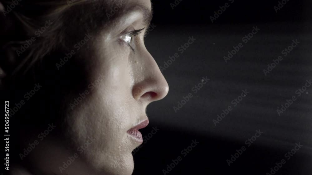 Side profile of a business woman with a light shaft striking her face Side profile of a business woman with a light shaft striking her face