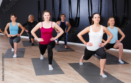 Group of sporty girls practicing various yoga positions during training indoors
