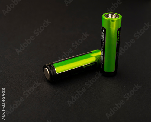 Two green AA batteries isolated on a black background. accumulators photo