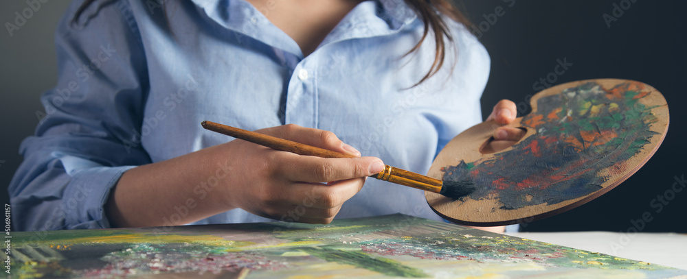 Fototapeta premium the artist paints with a brush in his hand