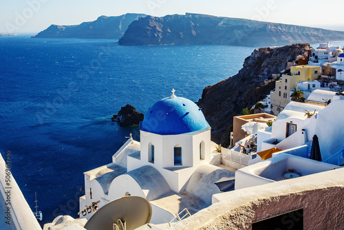 Vacation on Santorini island, Travel to Greece. The blue dome of the white church near the sea and caldera.