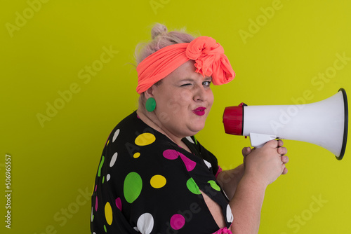 Funny plus size woman woman posing isolated on pastel green background studio portrait. People emotions lifestyle concept. Mock up copy space. Screaming in megaphone. 