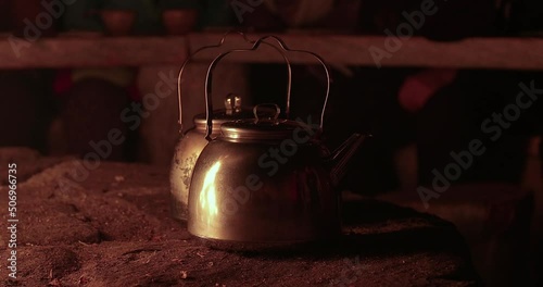 Tea pots by the fire in a hut photo