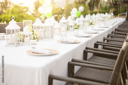 Long dining table at wedding. Tableware decorations with white tablecloths at outdoor wedding