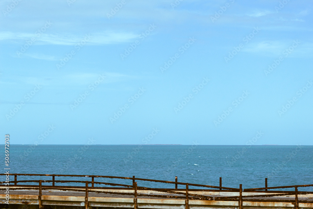 Blue sky with few clouds, sea and a bridge at the bottom Blue sky with few clouds, sea and a bridge at the bottom