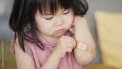 Foto 怪我をした腕の絆創膏を気にする4歳の子供（育児・子育て）