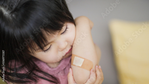 怪我をした腕の絆創膏を気にする4歳の子供（育児・子育て） photo