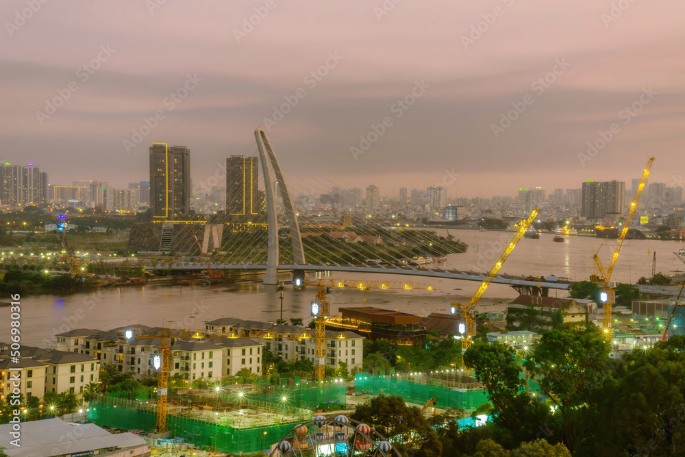 Aerial view of Bitexco Tower, buildings, roads, Thu Thiem 2 bridge and Saigon river in Ho Chi Minh city - Far away is Landmark 81 skyscraper. Travel concept.