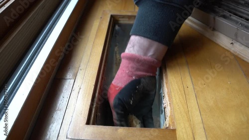 Slow motion of dust and dirt being hand removed from an air conditioning floor duct photo