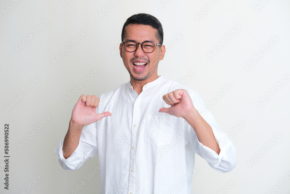 Adult Asian man showing enthusiastic expression while pointing to his self Adult Asian man showing enthusiastic expression while pointing to his self