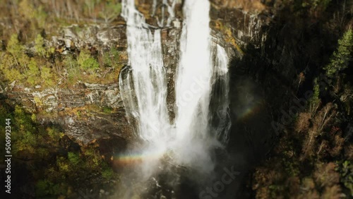 Aerial view of the stunning Skjerfossen waterfall. A powerful torrent of whitewater falls from the cliffs. A rainbow emerges in the water spray. photo