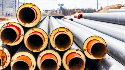 Insulated pipe. Large metal pipes with a plastic sheath at a construction site. Modern pipeline for supplying hot water and heating to a residential area.