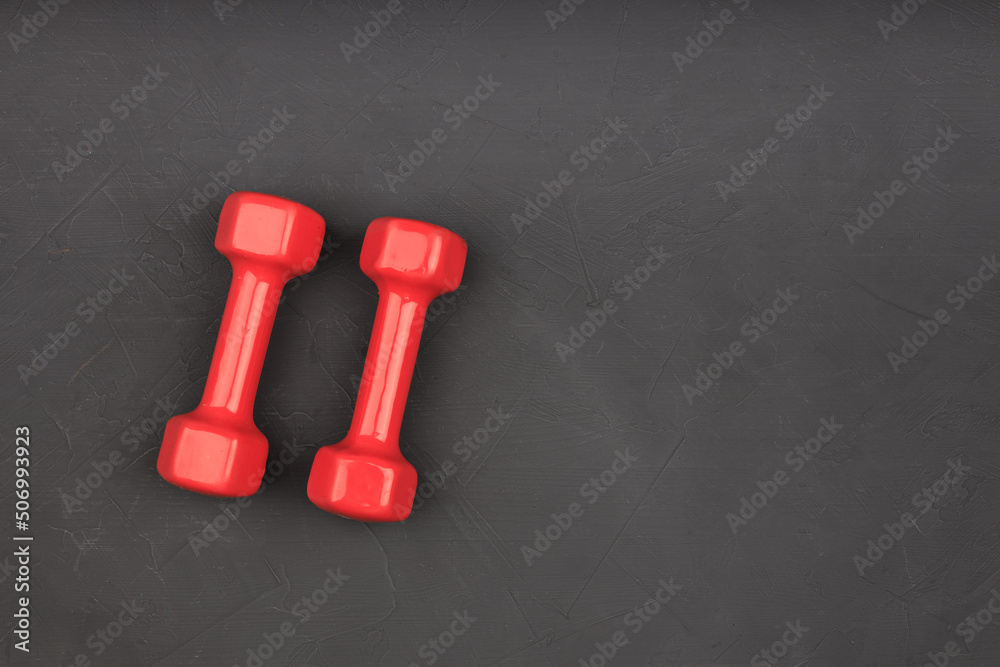 two red dumbbells on a black background two red dumbbells on a black background