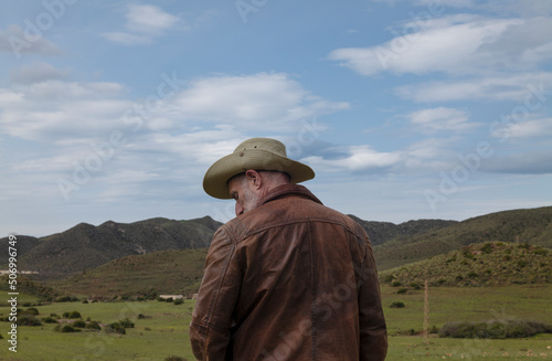 Portrait of adult man in cowboy hat on field © WeeKwong